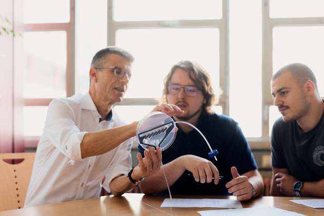 Prof. Dario Anselmetti (links) spricht mit seinem Doktoranden und Studenten über das vergrößerte Modell des Filters.