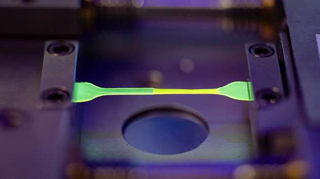 In Abhängigkeit von der Kraft ändert sich die Farbe der Probe. Verantwortlich dafür sind Farbstoffmoleküle aus dem Bereich sogenannter Mechanophore, die sich ändernde Bauteilspannungen durch Farbänderungen sichtbar machen.