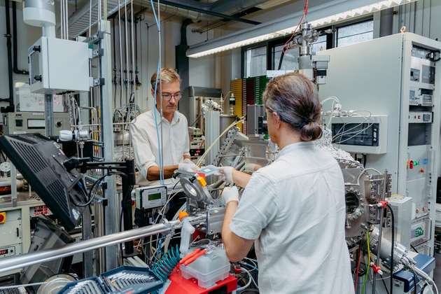 Die Physiker Prof. Martin Feneberg (links) und Prof. Armin Dadgar an der Magnetron-Sputter-Epitaxie-Anlage im Institut für Physik der Otto-von-Guericke-Universität Magdeburg.