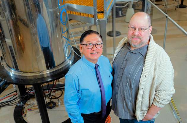 Bin Yang, Professor an der WSU-Abteilung für Biologische Systemtechnik, steht mit Andrew Lipton, Wissenschaftler am Pacific Northwest National Laboratory, neben einem Kernspinresonanzgerät, das bei Experimenten zu neuen nachhaltigen Kraftstoffen eingesetzt wird.
