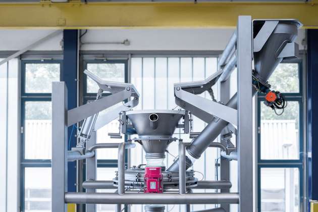 Staubdichte Big Bag Entleerstation mit Walkvorrichtung und angebautem Schutzsieb (Vibrationsrundsieb). Das System wird über einen Verdrängungsfilter am Entleertrichter und Saugfilter über den Deckel des Rundsiebs entstaubt.