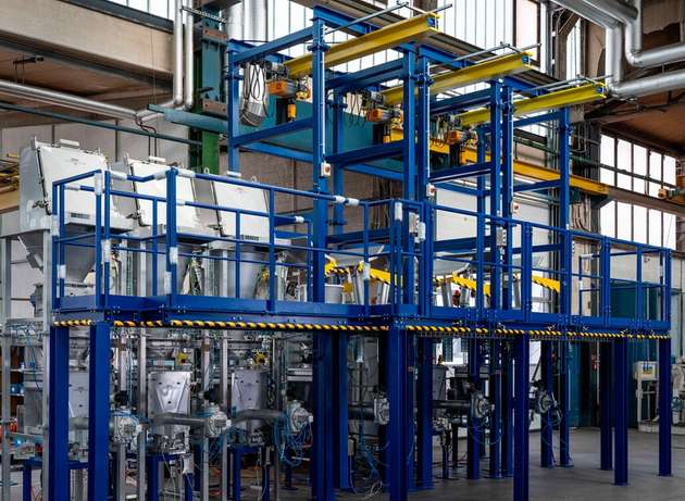 Probeaufbau und Funktionstest einer Anlage in der Produktion bei Engelsmann. Die Big Bags werden mit Kranbahnen eingehoben. Der Anschluss der Big Bags und die manuelle Sackaufgabe geschieht über eine Bedienbühne im oberen Stockwerk.