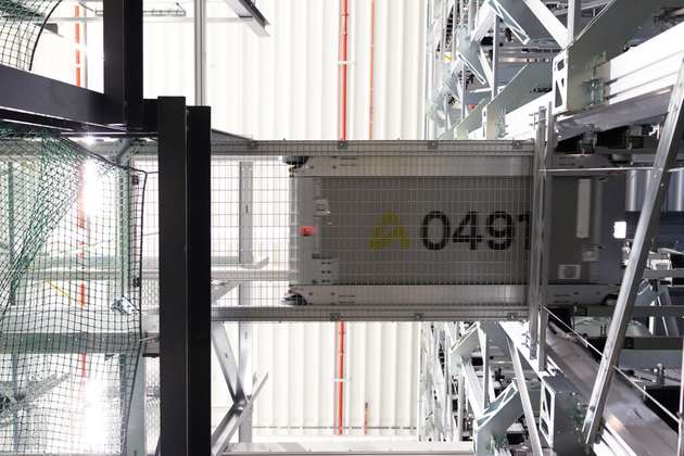 Der Transportshuttle von unten zwischen zwei Hochregalen fotografiert. Wie die anspruchsvolle Eigenentwicklung von oben aussieht, behält advastore lieber für sich, um Wettbewerbern keine Details zu verraten.