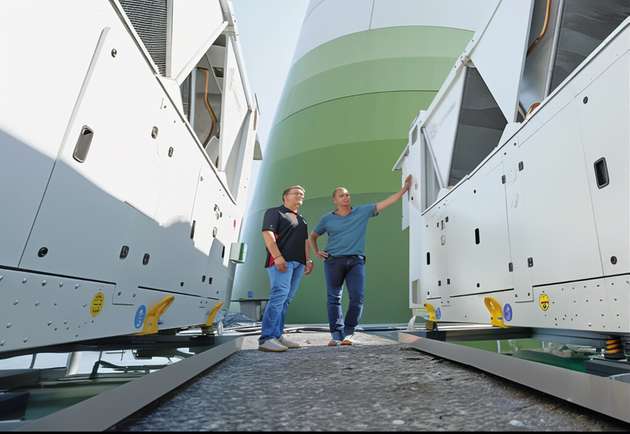 Zwei Kühlcontainer der Firma Skadec befinden sich hinter der Windenergie-Anlage.