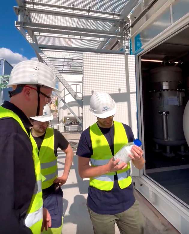 Die symbolische Übergabe der ersten Flasche e-Fuel durch den Inbetriebnahmeleiter.
