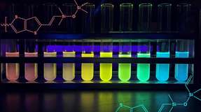 Reagenzgläser, die die neuen Silikon-Copolymere enthalten, getrennt nach Kettenlänge, von lang bis kurz, liefern den visuellen Beweis für die unterschiedliche Bandlücke im neuen Halbleitersilikon. Bei Bestrahlung mit UV-Licht entsteht ein Regenbogen von Bechern, da sich die längeren Kettenlängen zum roten Ende des elektromagnetischen Spektrums hin verschieben und weniger Energie benötigen, um Licht mit niedrigeren Energien zu absorbieren und auszusenden.
