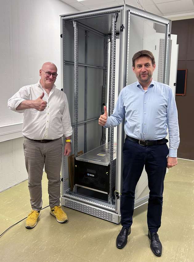 Der Quantenbeschleuniger von Quantum Brilliance hat eine kompakte Größe: Dr. Mark Mattingley-Scott (links) und Prof. Dr. Rüdiger Quay bei der der Installation im Fraunhofer IAF.