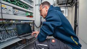 Ein Servicetechniker von Klima Kälte Kopp bei der Inbetriebnahme eines modernen Kühlanlagen-Systems: Über eine Software-Schnittstelle werden alle Funktionen der Anlage überwacht, parametriert und auf maximale Effizienz abgestimmt.