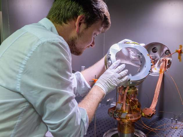 IPP-Wissenschaftler Paul Huslage montiert eine Modellspule im Teststand. Darin lassen sich Magnetspulen bei Temperaturen von 20 K (-253 °C) unter Vakuumbedingungen untersuchen.