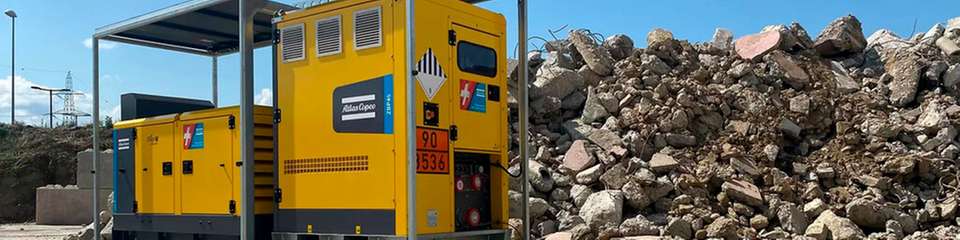 Die Hybrid-Batteriespeichersysteme von Atlas Copco bestehen aus einem dieselbetriebenen Stromerzeuger (links in der Anlage) und einem elektrischen Energiespeicher (rechts), die auf einem gemeinsamen Gehäuserahmen montiert sind.