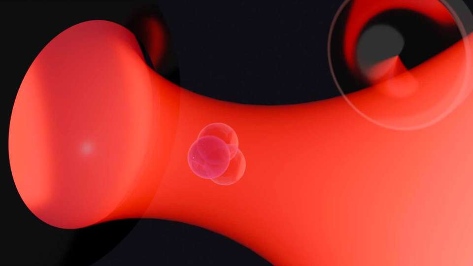 Die ETH-Forschenden hielten ein Nanoobjekt (Bildmitte) in einer Laserfalle fest. Rot dargestellt ist das Laserlicht, das mit einer Linse gebündelt wird.