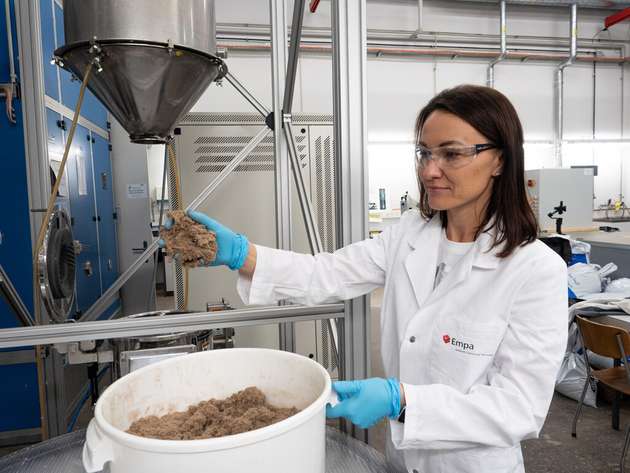 Empa-Forscherin Yuliia Dudnyk mit der flockigen Lignocellulose, dem Ausgangsmaterial für die Leiterplatte.