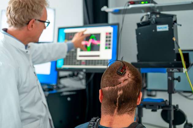 Prof. Simon Jacob und Studienteilnehmer Michael Mehringer besprechen Daten, die über eine Hirn-Computer-Schnittstelle gewonnen wurden. Die Elektroden wurden dem querschnittsgelähmten Studienteilnehmer in einer europaweit erstmaligen Operation eingesetzt.