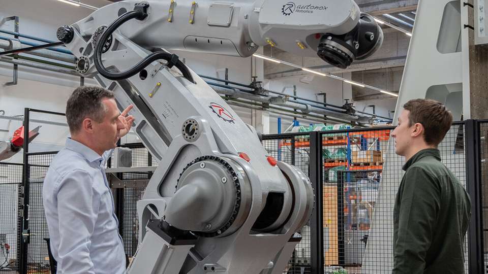 Betriebsleiter Clemens Ratajczak und Projektingenieur Léopold Hurst bei der technischen Begutachtung einer mehrachsigen Robotermechanik in der Fertigungshalle von Autonox in Willstätt