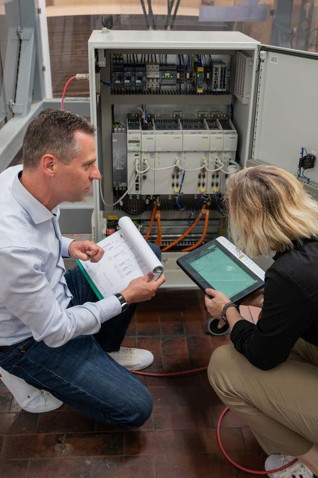 Clemens Ratajczak und Elisabeth Schärtl (verantwortlich für das Partnerprogramm Linked Robotics von Autonox) inspizieren einen offenen Keba-Schaltschrank.