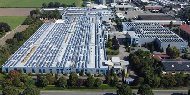 Luftaufnahme des Setex-Werksgeländes in Deutschland mit großflächigen Solaranlagen auf den Hallendächern.