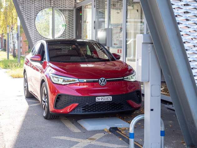 Ein umgerüstetes E-Auto lädt kabellos über die im Boden integrierte Spule – der Ladevorgang startet automatisch, sobald das Fahrzeug korrekt parkiert ist.