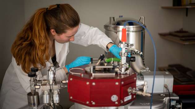 Johanna Byloff analysiert die Proben an der Beschichtungsmaschine des Empa-Spin-offs Swiss Cluster vor.