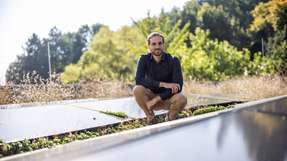 Der Physiker Dr. Lukas Wagner zwischen Solarmodulen auf dem Dach des Physikgebäudes der Universität Marburg. Mit Prof. Dr. Jan Christoph Goldschmidt und weiteren Forschenden hat er in einer aktuellen Studie untersucht, welche Nachhaltigkeitsziele Photovoltaik für eine globale Hochskalierung erfüllen muss.