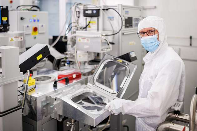 Reinraummitarbeiter am Fraunhofer THM beim Einlegen eines Wafers in die Transferkammer eines Abscheide- / Ätzclusters für die Strukturierung mittels Atomlagenätzung.