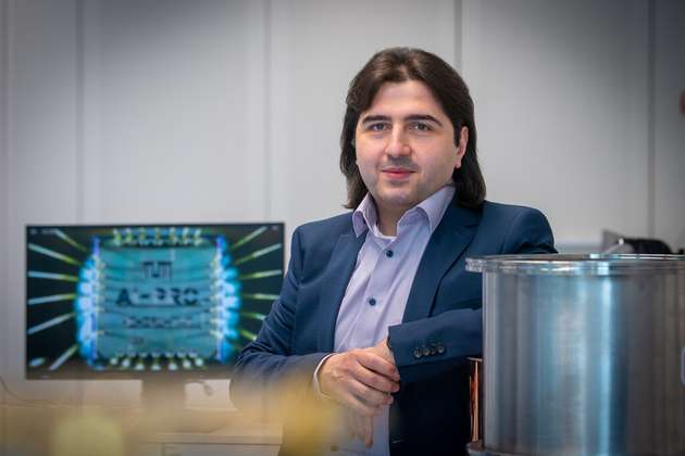 Prof. Hussam Amrouch neben seinem KI-Chip (in 2.000-facher Vergrößerung).