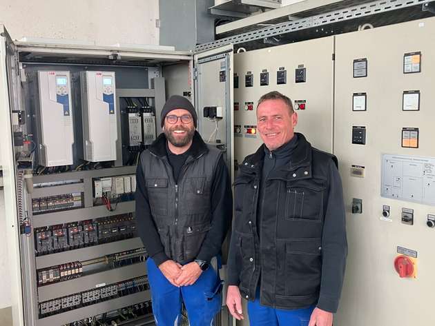 Betriebsleiter Bernd Ebe (rechts) und Elektriker Markus Siegler (links) vor dem Schaltschrank mit den beiden Single Drives ACQ580-01 für die Schneckenpumpen.  