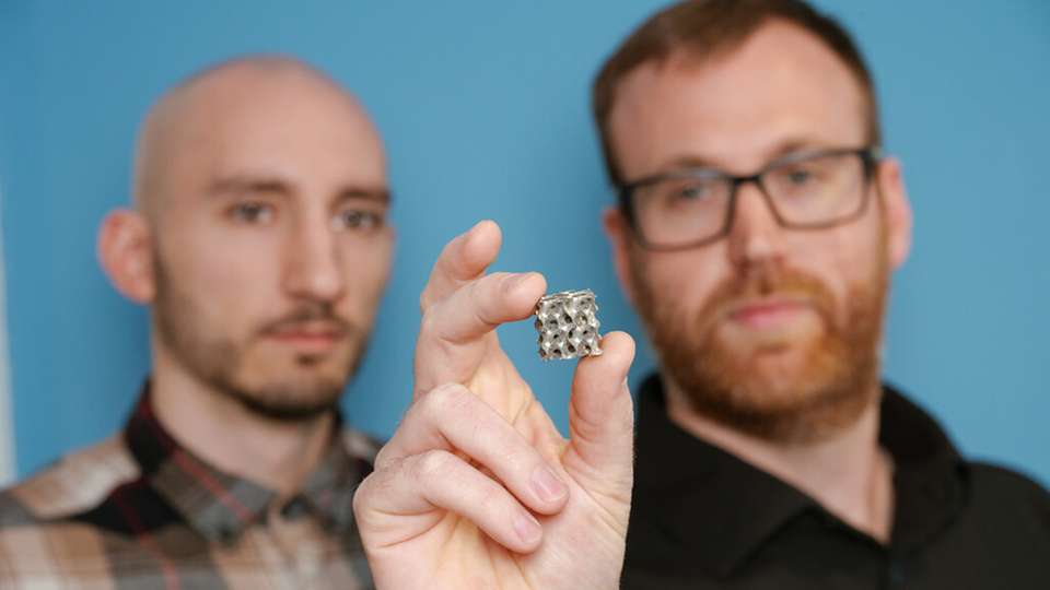 Ästhetische Kühlmittel: Die Doktoranden Thorben Trodler (links) und Michael Fries (rechts) feilen an filigranen Strukturen aus Nickel-Titan, durch die Luft oder Wasser strömen kann, um Wärme aufzunehmen und abzugeben. Die Legierung wird für Experimente Schicht für Schicht 3D-gedruckt.