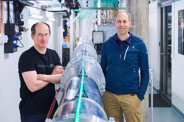 Andreas Wallraff und Renato Renner (von links nach rechts) neben der 30 m langen Verbindung zwischen zwei Quantenchips. Mit dem Experiment erzeugten ETH-Forschende erstmals zertifiziert perfekte Zufallszahlen.