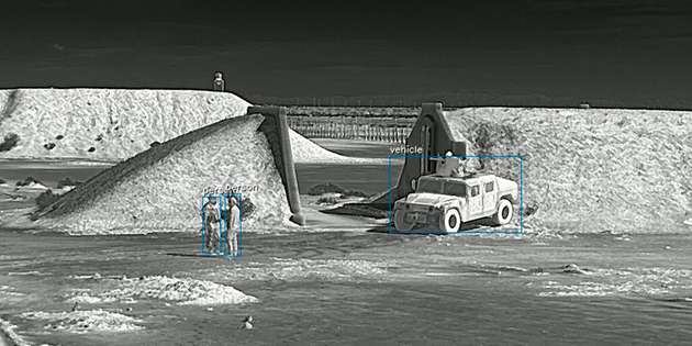 Prism Ground ISR von Teledyne FLIR OEM erkennt und klassifiziert Ziele – hier Personen und ein militärisches Fahrzeug – zuverlässig per KI-gestützter Infrarotbildgebung, selbst in unübersichtlichen Geländesituationen.