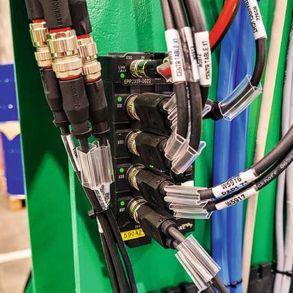 EtherCAT P-Box-Module verbinden die dezentralen I/Os für Achsen, Greifer und Sensoren über nur ein Kabel für Kommunikation und Power (rot/schwarz) mit der Steuerung im Schaltschrank.