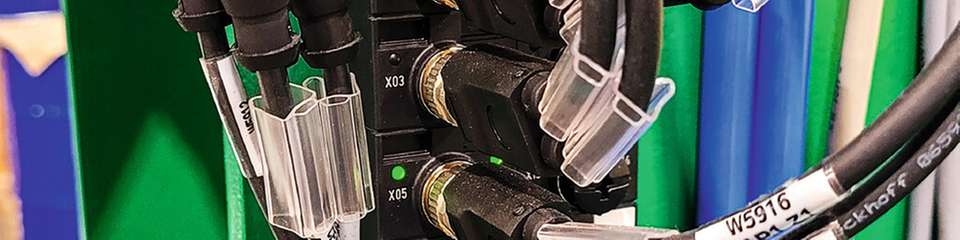 EtherCAT P-Box-Module verbinden die dezentralen I/Os für Achsen, Greifer und Sensoren über nur ein Kabel für Kommunikation und Power (rot/schwarz) mit der Steuerung im Schaltschrank.