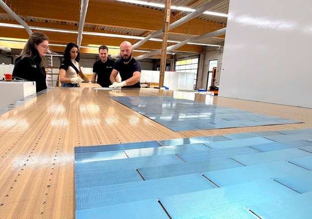 Bryan Mazor, CTO bei Source Energy, mit Kolleginnen und Kollegen am industriellen Schindel-Matrix-Stringer der Firma M10 Solar Equipment.