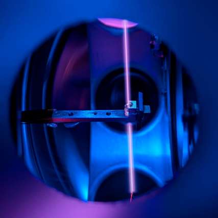 Der Kristall in der Vakuumanlage mit Laserstrahl, der die Thorium-Kerne anregt.
