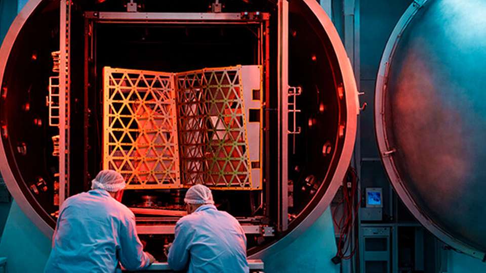 Zwei Wissenschaftler vor einer Vakuumkammer für Testzwecke.