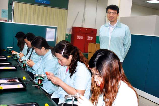 Chih-Hang Cheng mit Technikerinnen in der Fertigung in Kaohsiung im Süden Taiwans.