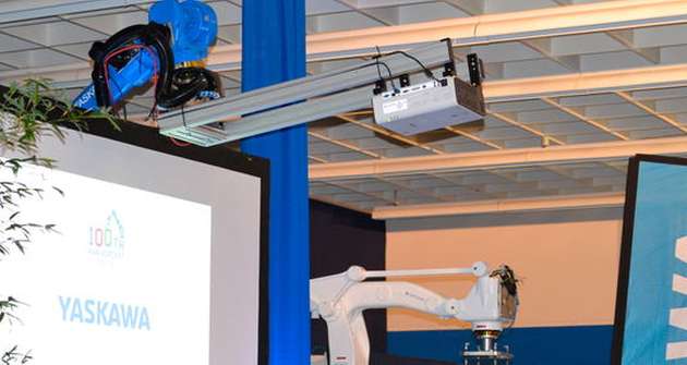 Transportable Beamer stehen bei Präsentationen gerne im Weg. Nicht so dieser, der von einem Motoman-Roboter an seinen Platz gefahren wird.