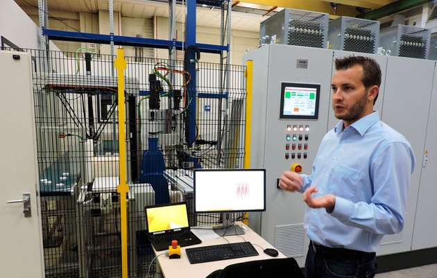 Daniel Beckmann von der Forschungsgruppe Identifikation & Regelung, erläutert die Arbeit an der Montage-, Handhabungs- und Fördertechnikzelle, die mit Controllern und Invertern von Lenze bestückt ist.