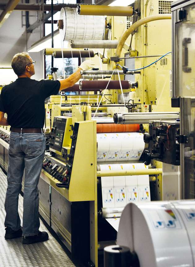 Es sind nur kleine Handgriffe, welche die Werker machen müssen – zur Kontrolle, damit alles richtig läuft. Denn die zwölf Druckmaschinen produzieren fast wie von selbst mehrere Milliarden Etiketten pro Jahr.