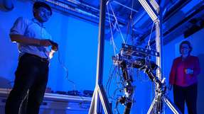 Doktorand Hongxi Zhu und Professorin Ulrike Thomas probieren gemeinsam den Laufroboter aus, in dem das nachgiebige Robotergelenk integriert werden kann.